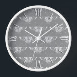 Stilisierter Art-Deco-Schmetterling in Grautönen Wanduhr<br><div class="desc">Reproduktion eines stilisierten Art-Deco-Schmetterlingsmusters - Hellsilber grau / grau auf einem tiefer liegenden kohlegrauen Hintergrund</div>