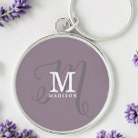 Stilvolle Kalligraphie Monogramm und Name Lila Schlüsselanhänger<br><div class="desc">Ein wunderschöner feminininer Schlüsselanhänger mit elegantem Stilnamen und Monogramm mit klassischen Serifen und einer verzierteren Skriptkalligraphie in einem ausgewogenen und schönen Layout. Die drei Elemente verschmelzen mit einer ausgeklügelten Harmonie und kreieren Ihr eigenes Markenlogo. Hier zeigt sich ein trendiger,  staubiger lila Hintergrund mit Monogrammelementen in weiß und lila grau.</div>