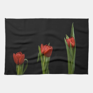Stilvolle vibrierende rote Tulpen auf schwarzem Handtuch