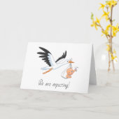 Storch, der ein Baby trägt, das sich selbst ernähr Karte (Gelbe Blume)