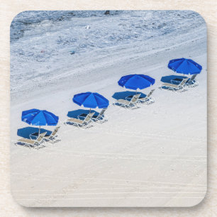Strand-Stühle mit blauem Regenschirm auf Getränkeuntersetzer