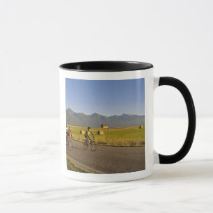 Straßenradfahrer fahren eine ländliche Straße hinu Tasse