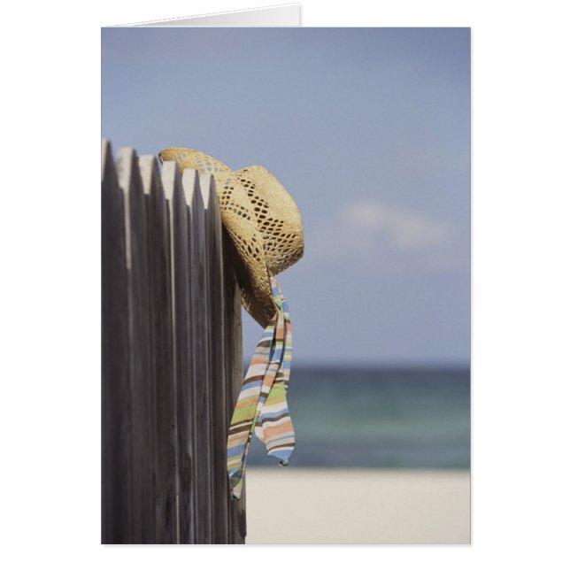 Strohhut auf Zaun am Strand (Vorne)