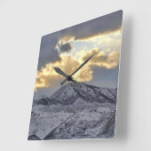 Sturmsonnenuntergang über schneebedeckten Bergen Quadratische Wanduhr (Winkel)
