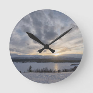 Sunset over frozen lake runde wanduhr