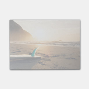 Surfbrett legt auf den Strand, während Sonne Post-it Klebezettel