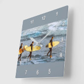 Surfers Head Into the Ocean to Catch the Last Wave Quadratische Wanduhr (Winkel)