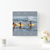 Surfers Head Into the Ocean to Catch the Last Wave Quadratische Wanduhr (Zuhause)
