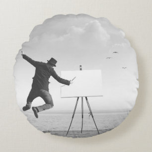 surrealer Schwarz-Weiß-Kunstmaler, der auf einer L Rundes Kissen
