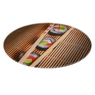 Sushi und hölzerne Essstäbchen Schneidebrett