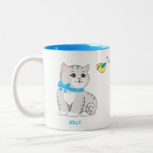 Süße graue getigerte Kätzchenkatze und kleiner Vog Zweifarbige Tasse