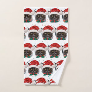 Süße schwarze Katze mit Weihnachtsmannmütze an Wei Handtuch