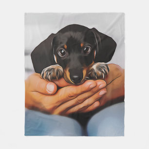 Süßer Dachshund-Welpe liegt auf menschlichen Knien Fleecedecke