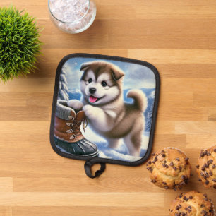 Süßer Husky-Welpe spielt in schneelandschaftlicher Topflappen