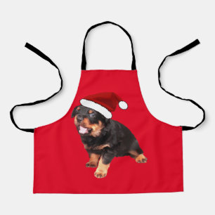 Süßer Rottweiler-Welpe mit Cartoon-Weihnachtsmannm Schürze