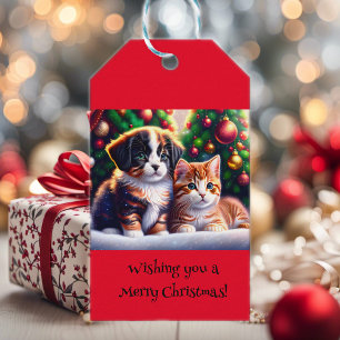 Süßer Welpe und Katze unter dem Weihnachtsbaum ind Geschenkanhänger