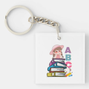 Süßes Mädchen, das Bücher und ABC-Schlüsselanhänge Schlüsselanhänger