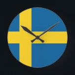 Sweatflagge Runde Wanduhr<br><div class="desc">Flagge Schwedens. Die Flagge Schwedens ist ein skandinavisches Kreuz, das sich bis an den Rand der Flagge erstreckt. Dieses skandinavische Kreuz repräsentiert das Christentum. Das Design und die Farben der schwedischen Flagge werden vermutlich durch die gegenwärtige Wappen Schwedens von 1442 inspiriert, die blau durch eine Kreuzpattée aus Gold aufgeteilt und...</div>