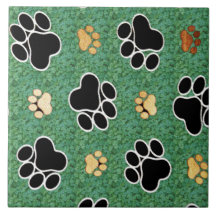 Tan und schwarze Pfote auf grünem Gras