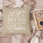 Tan & White Life ist besser in der Hütte Kissen<br><div class="desc">Rustikales modernes Kissen mit einem hellbeigen Hintergrund mit "Life is better at the cabin" überlagert in weißer Typografie. Personalisieren Sie die Rückseite mit Ihrem Familiennamen und dem festgelegten Jahr.</div>