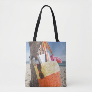 Tasche, die am Baum-Stamm an Sandy-Strand hängt Tasche