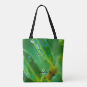 Tasche mit Regentropfen auf grünen Blättern (Rückseite)