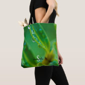 Tasche mit Regentropfen auf grünen Blättern (Von Nahem)
