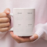 Tasse 2025 | Weich Pastellrosa |<br><div class="desc">Genießen Sie Ihre Lieblingsgetränke beim bleibe mit dieser 2025 Kalender-Tasse in einem weichen pastellrosa Design. Diese Tasse vereint Praxisnähe und Eleganz und bietet einen ganzjährig gültigen Kalender, der sich perfekt für eine schnelle Terminreferenz eignet. Die sanfte pastellfarbene Farbe verleiht dem Haus eine Touch der Eleganz, die es zu einer idealen...</div>