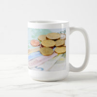 Tasse mit Euro Scheinen und Münzen