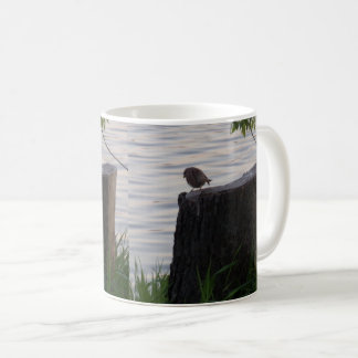 Tasse mit Vogel auf einem Baumstumpf
