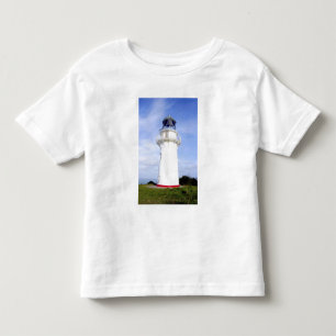Te Araroa, Neuseeland. Ein Leuchtturm gibt Kleinkind T-shirt