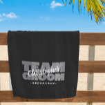 Team Groom Trauzeuge Hochzeit Cool Retro Black Poo Strandtuch<br><div class="desc">Das speziell für Ihre Trauzeugen konzipierte Strandtuchdesign "TEAM GROOM" in fett hellgrau auf solidem schwarzem Hintergrund. Passen Sie den Namen des Trauzeugen in einem knackigen weißen Skript an. Nachstehend finden Sie den Titel oder den benutzerdefinierten Text. Alle Farben in diesem Design sind im Bereich des Zazzle-Designs anpassbar! Nachricht mit Fragen...</div>