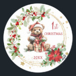 Teddy Bear Foliage Poinsettia Baby 1. Weihnachten Runder Aufkleber<br><div class="desc">In diesem Design präsentiert sich ein Teddybär mit Weihnachtsmannmütze und ein Weihnachtskranz mit Poinsettia,  grünem Blattwerk und roten Beeren. Sie können Text nach Ihren Anforderungen anpassen.</div>