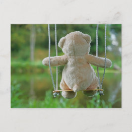 Teddy beertje dat op een schommel zit in de natuur postkarte