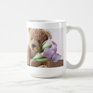 Teddybär, der Callalilien-Tasse hält Kaffeetasse