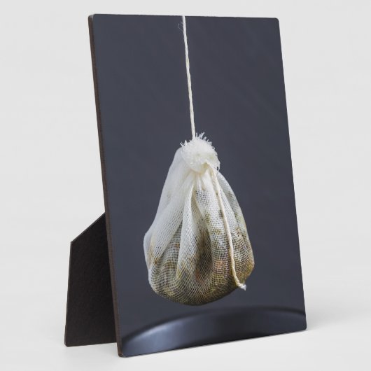 Teebeutel hängt in einer Tasse Fotoplatte (Seite)