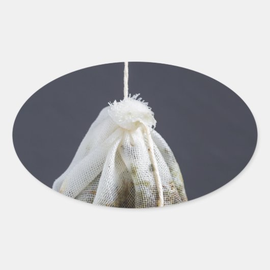 Teebeutel hängt in einer Tasse Ovaler Aufkleber (Vorderseite)