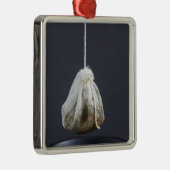 Teebeutel hängt in einer Tasse Silbernes Ornament (Rechts)