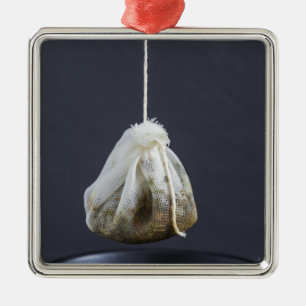 Teebeutel hängt in einer Tasse Silbernes Ornament