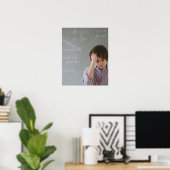 Teenaged boy in front of blackboard with math poster (Heimbüro)