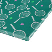 Tennis-Racket und ein kleines Muster-Grün Schneidebrett (Ecke)