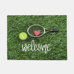 Tennisball und Schläger auf Grün Fußmatte