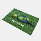 Tennisschläger mit Ball auf grünem Gras Fußmatte (Schrägansicht)