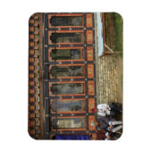 Three men sit on a bench at the Memorial Chorten Magnet (Vertikal)