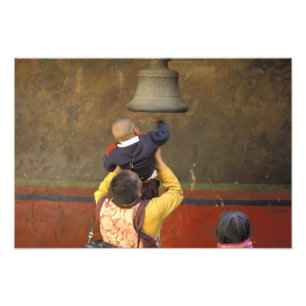 Tibetischer buddhistischer Mönch hebt einen Jungen Fotodruck