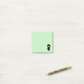 Tiny Ninja Holding Throwing Star auf Green Post-it Klebezettel (Auf Schreibtisch)