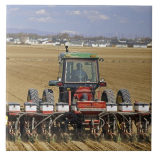 Traktor, der eine Mais-Sämaschine zieht. Fliese