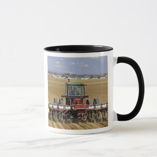 Traktor, der einen Maissaatgutpflanzer zieht Tasse (Rechts)