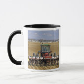 Traktor, der einen Maissaatgutpflanzer zieht Tasse (Links)