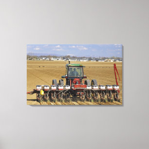 Traktor zieht eine Mais-Sämaschine. Leinwanddruck
